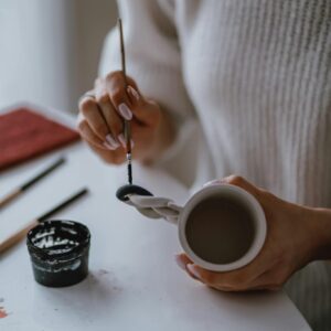 Photo of a Person Painting a Mug